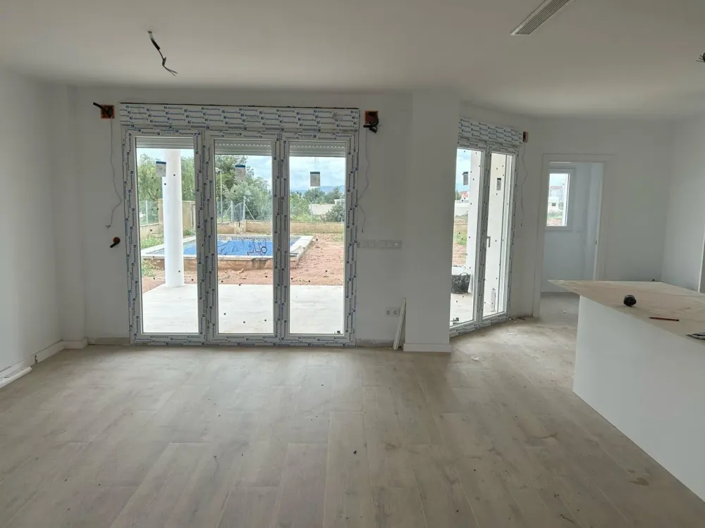 Salón de vivienda unifamiliar en obra antes de instalar suelo y cocina, reforma integral en Santiago