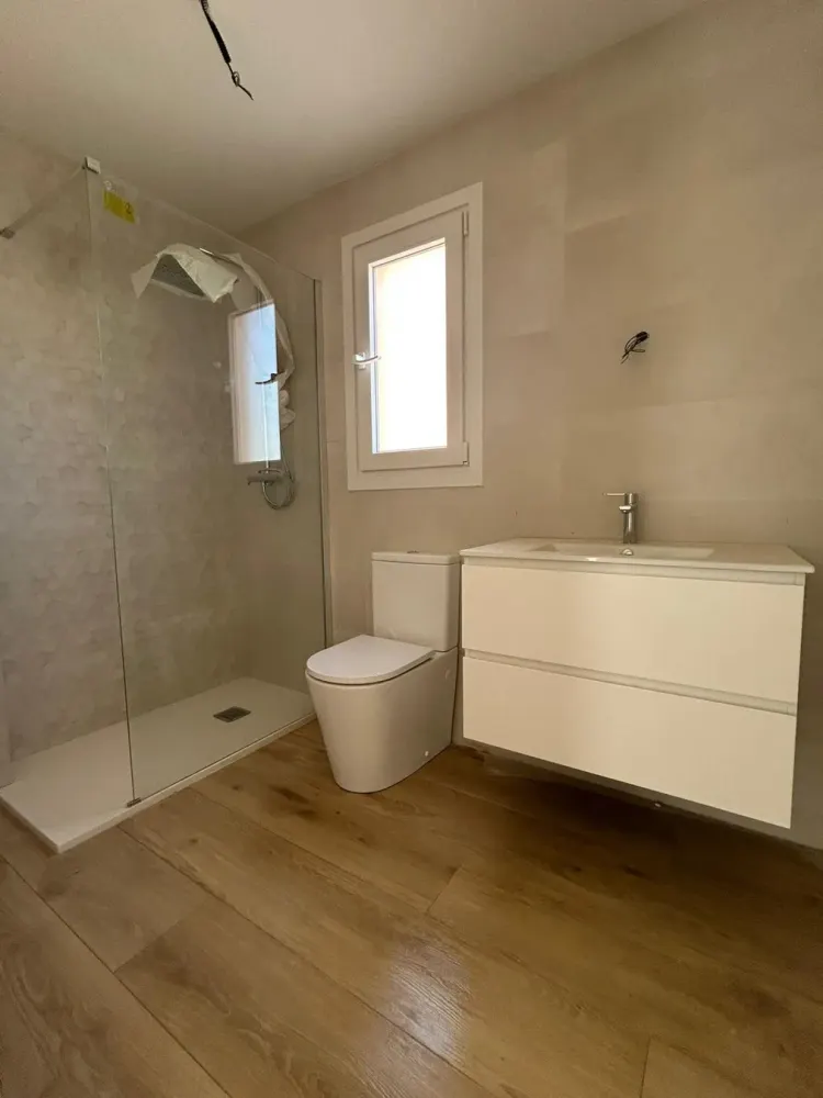 Baño reformado en Santiago con ducha y revestimiento en tonos beige