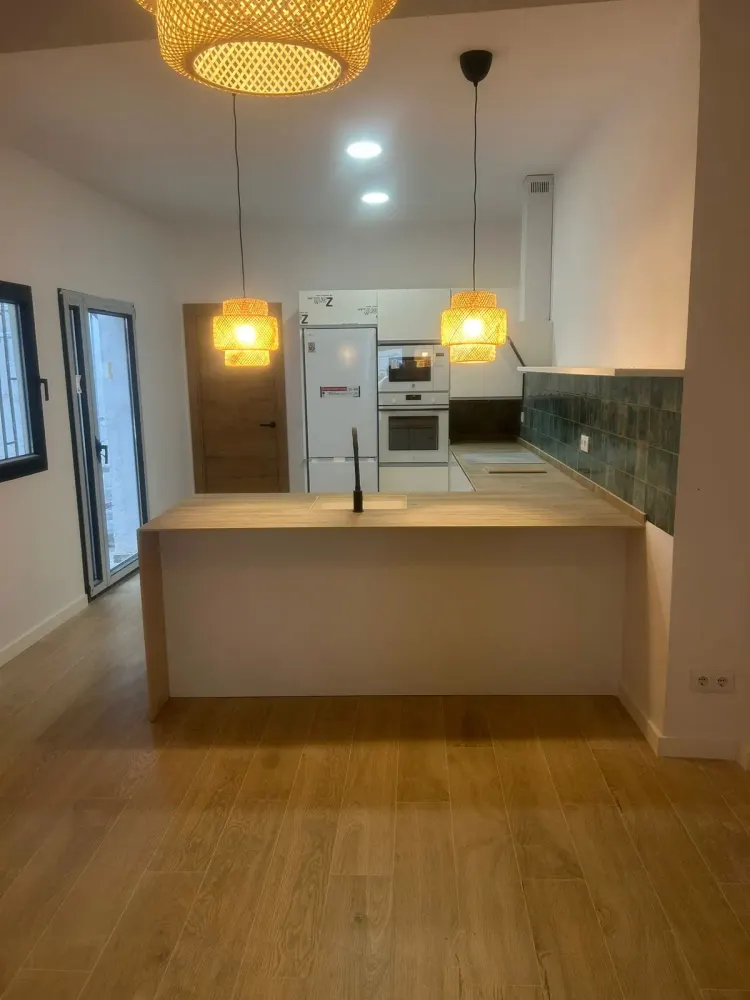 Reforma de cocina en Santiago con horno integrado, campana y lámparas de fibra