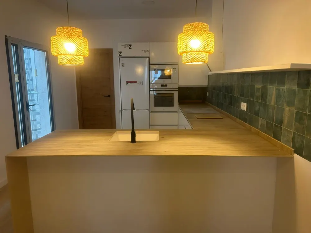 Reforma de cocina en Santiago con frente de azulejo verde y muebles claros