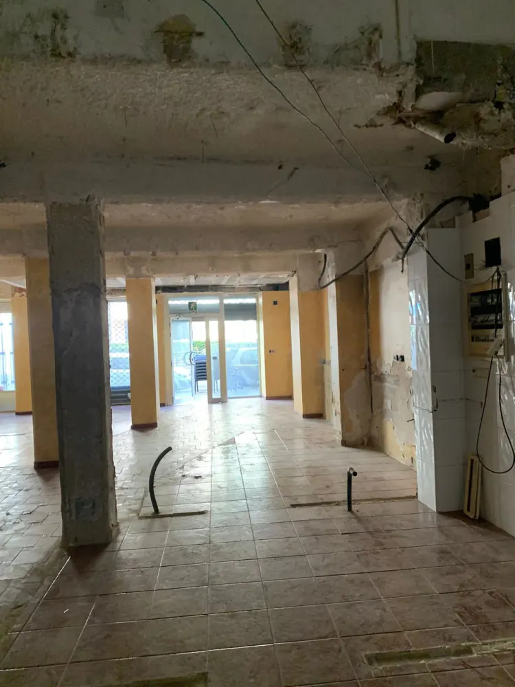 Local comercial en estado inicial antes de reformar en Santiago de Compostela, con columnas y suelo antiguo