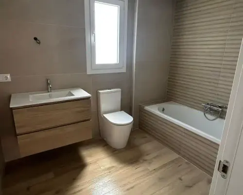 Baño pequeño reformado en Santiago de Compostela con mueble suspendido y ducha a ras de suelo