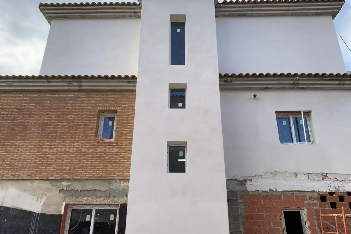 Fachada trasera de vivienda unifamiliar revestida en Oroso