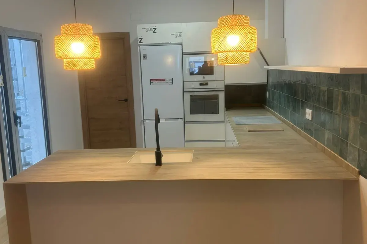 Cocina con isla terminada en reforma de vivienda en Padrón